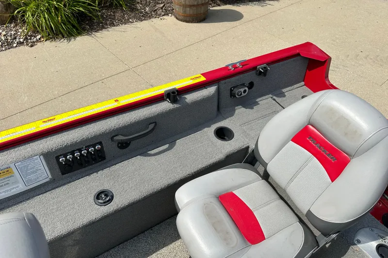 Slide: The Image of 2013 Tracker Pro Guide V 16 T boat interior with gray and red seating. - 6