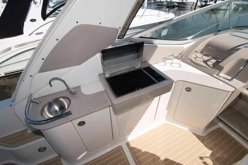 Slide: The Image of 2007 Sea Ray 310 Sundancer boat interior with sink, grill, and cup holders. - 11
