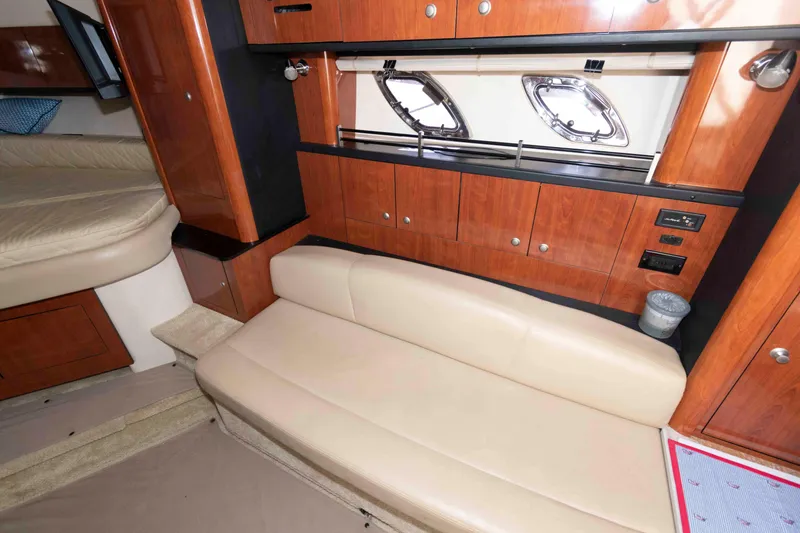 Slide: The Image of 2007 Sea Ray 310 Sundancer cabin interior with beige seating and wooden cabinetry. - 17