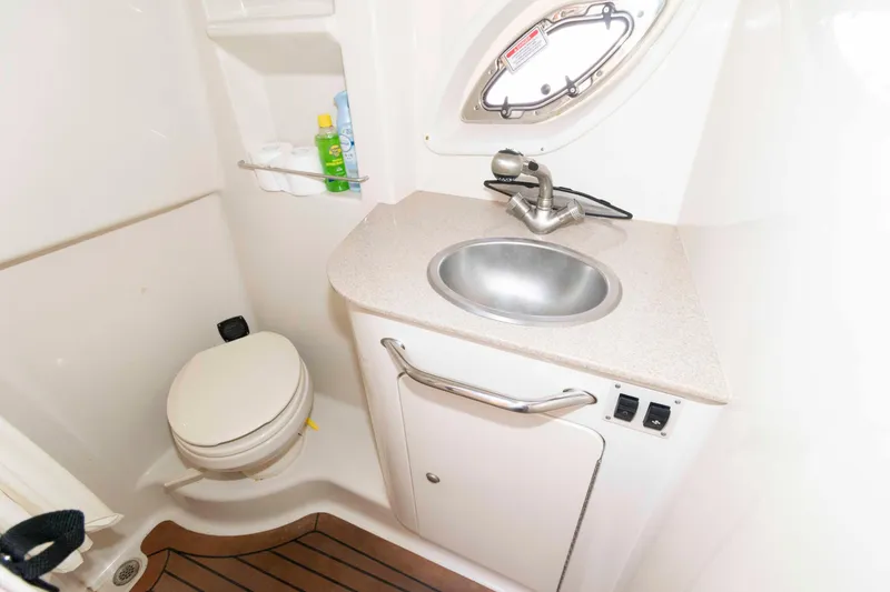 Slide: The Image of 2007 Sea Ray 310 Sundancer bathroom with sink, toilet, and storage shelves. - 19