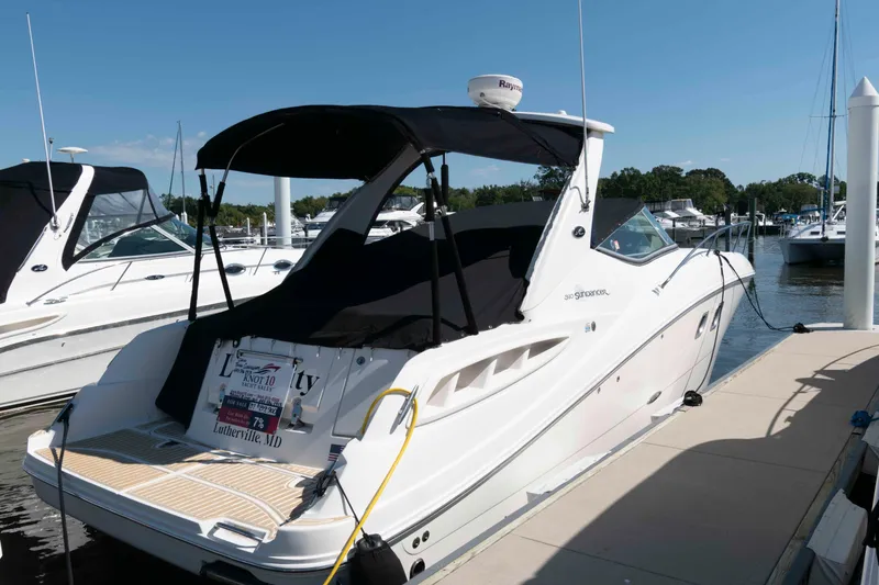 Slide: The Image of 2007 Sea Ray 310 Sundancer docked at marina, featuring sleek design and black canopy. - 3