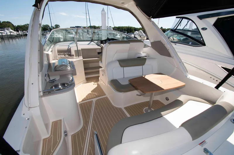 Slide: The Image of 2007 Sea Ray 310 Sundancer boat interior with seating and table, docked at marina. - 4