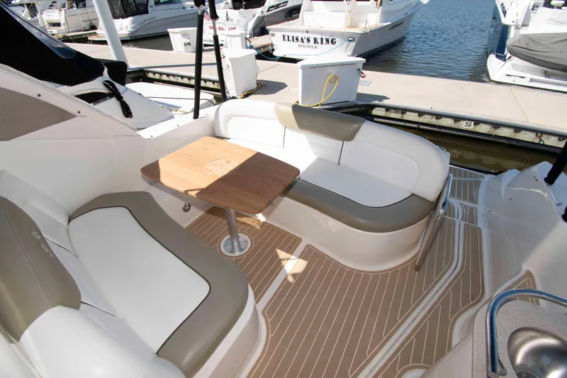 Slide: The Image of 2007 Sea Ray 310 Sundancer boat interior with seating and wooden table at marina. - 5