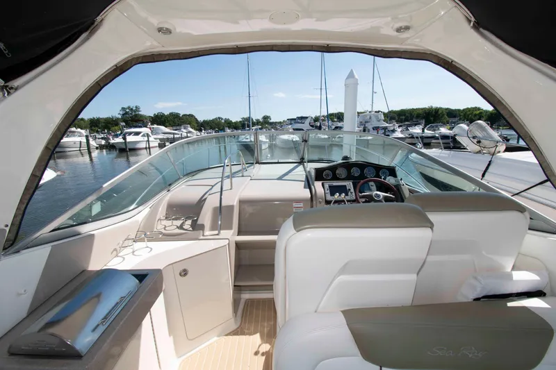 Slide: The Image of 2007 Sea Ray 310 Sundancer cockpit with marina view, featuring helm and seating area. - 6