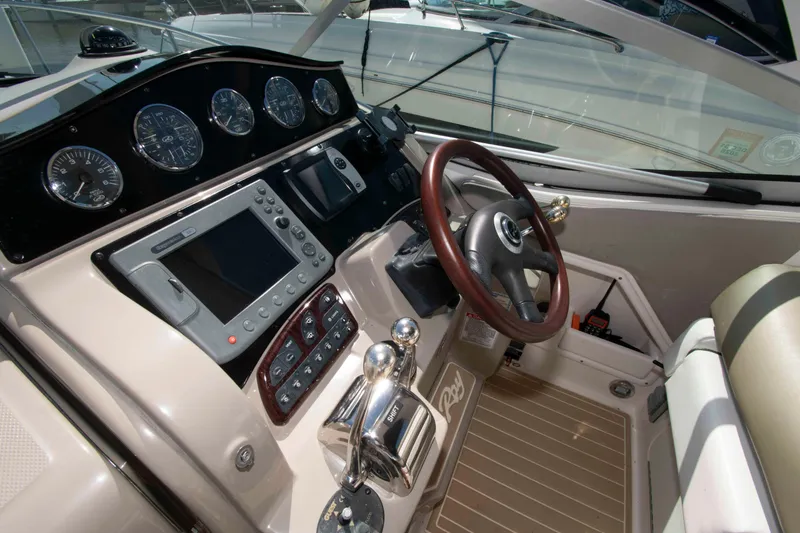 Slide: The Image of 2007 Sea Ray 310 Sundancer helm with gauges, steering wheel, and navigation controls. - 9