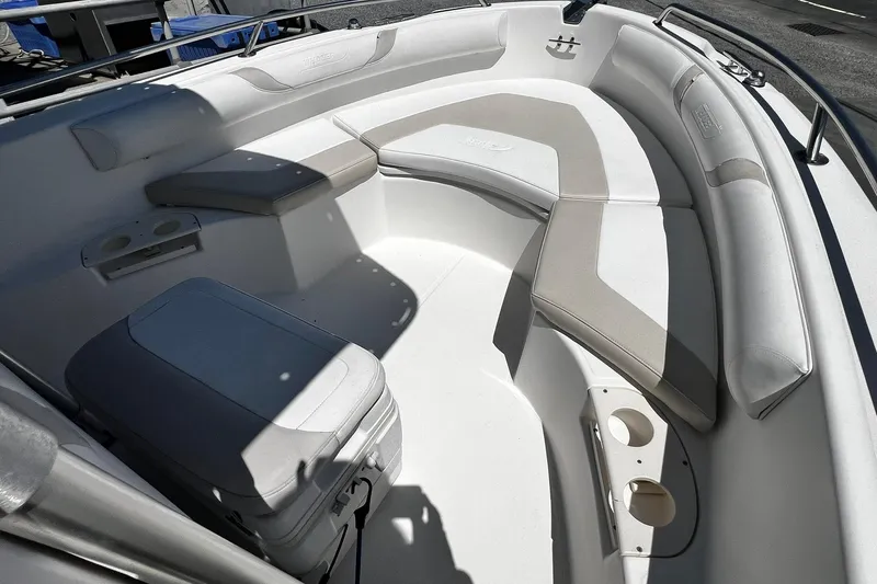 Slide: The Image of 2006 Boston Whaler 210 Outrage boat interior with cushioned seating and cup holders. - 12