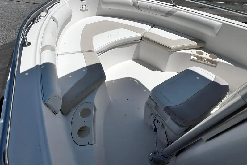 Slide: The Image of 2006 Boston Whaler 210 Outrage boat interior with cushioned seating and cup holders. - 13