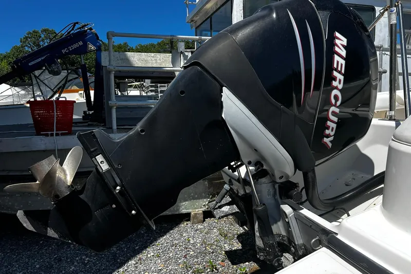 Slide: The Image of Mercury outboard motor on a 2006 Boston Whaler 210 Outrage boat, docked outdoors. - 24