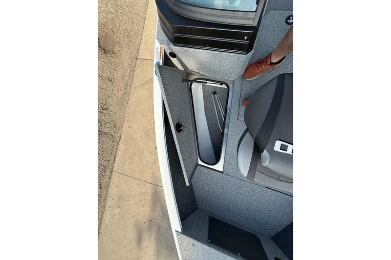 Slide: The Image of 2026 Lund 1675 Adventure Sport boat interior with open storage compartment and seating. - 12