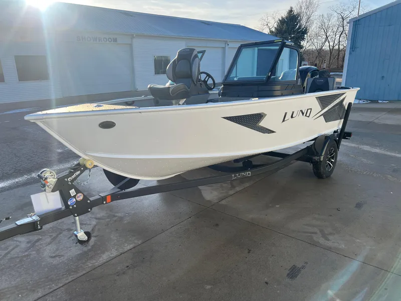 Slide: The Image of 2026 Lund 1675 Adventure Sport boat with seating, parked outdoors. - 2