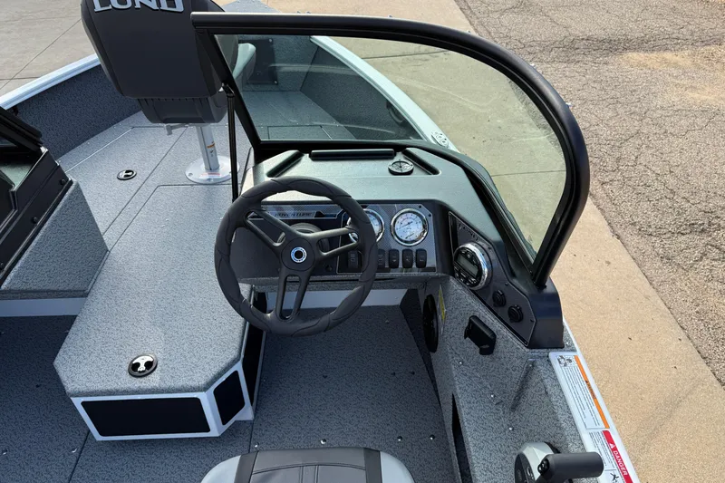 Slide: The Image of 2026 Lund 1675 Adventure Sport boat interior with steering wheel and dashboard controls. - 21