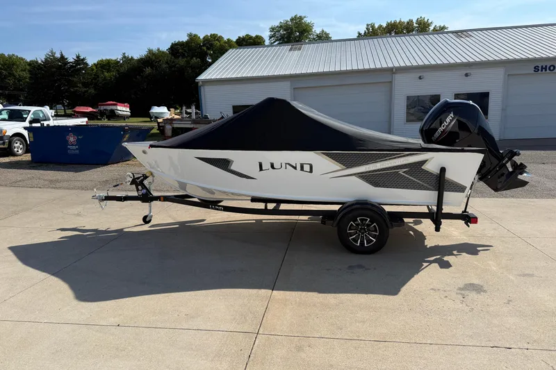 Slide: The Image of 2026 Lund 1675 Adventure Sport boat on trailer, covered and parked outdoors. - 31