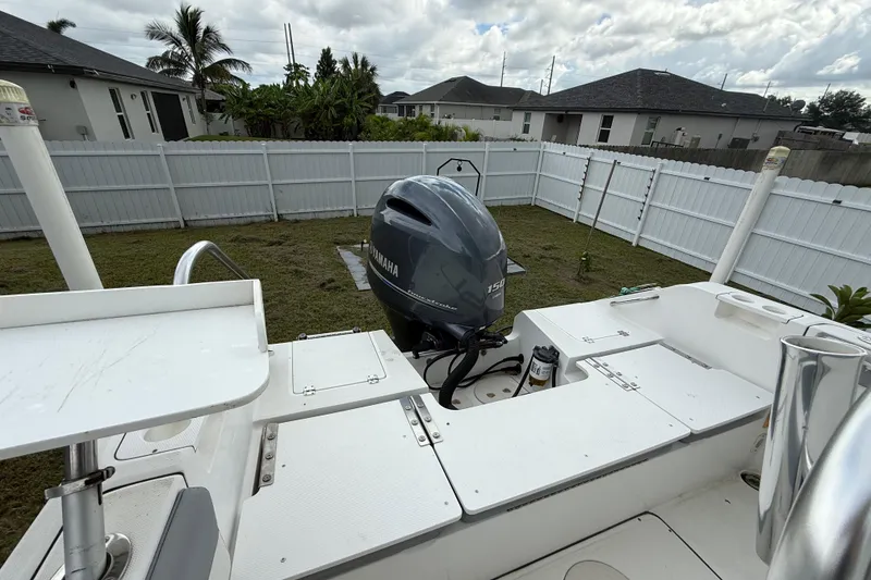 Slide: The Image of 2018 Release 208 RX boat with Yamaha 150 engine in a fenced yard. - 10
