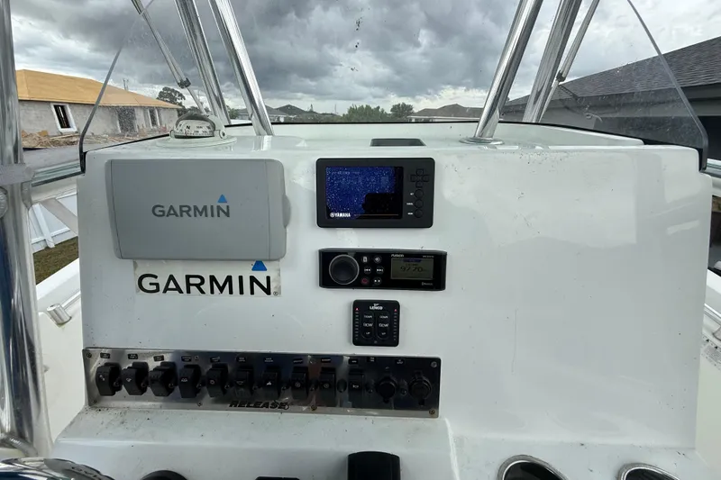 Slide: The Image of Boat dashboard with Garmin navigation system, Release 208 RX model, 2018, under cloudy skies. - 12