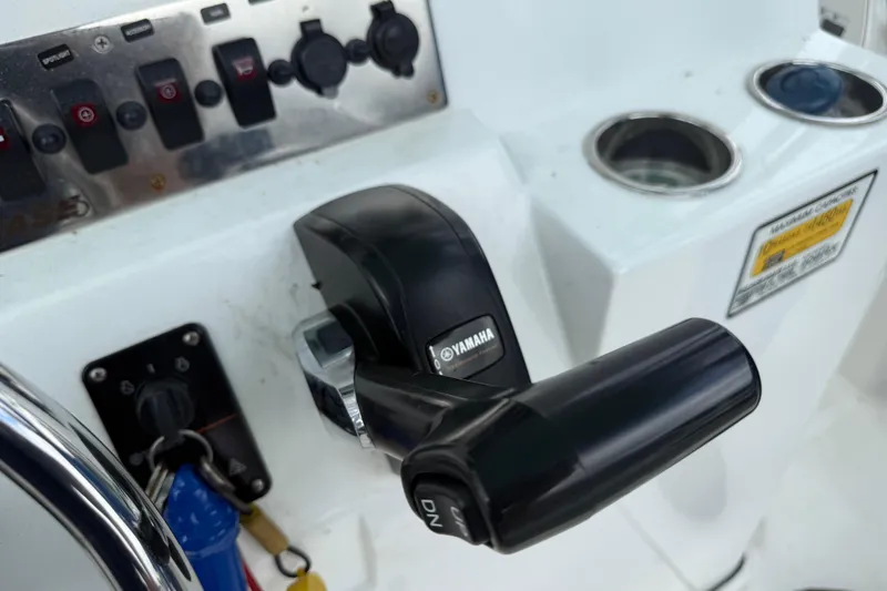 Slide: The Image of Boat control panel with Yamaha throttle lever, switches, and cup holder on a 2018 Release 208 RX. - 18