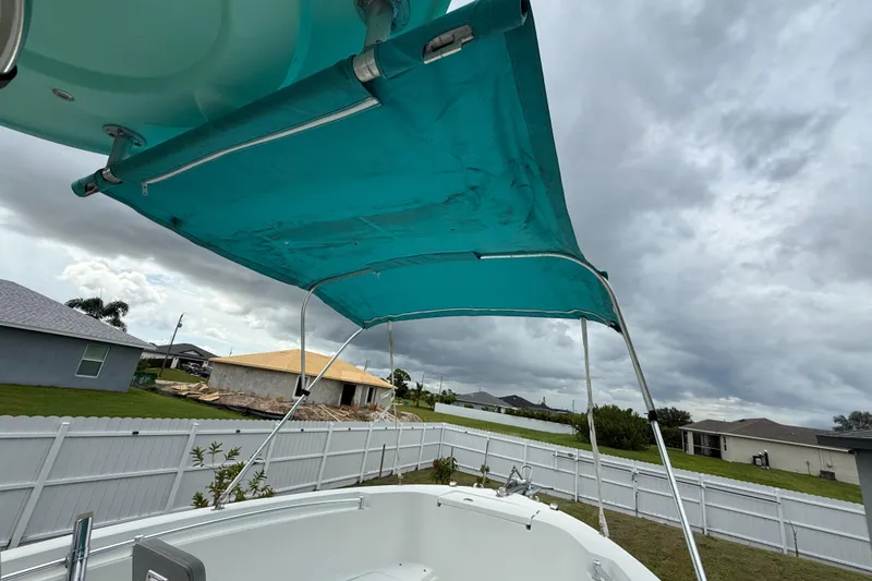 Slide: The Image of Boat with teal canopy in suburban backyard, cloudy sky. Release 208 RX, 2018 model. - 26