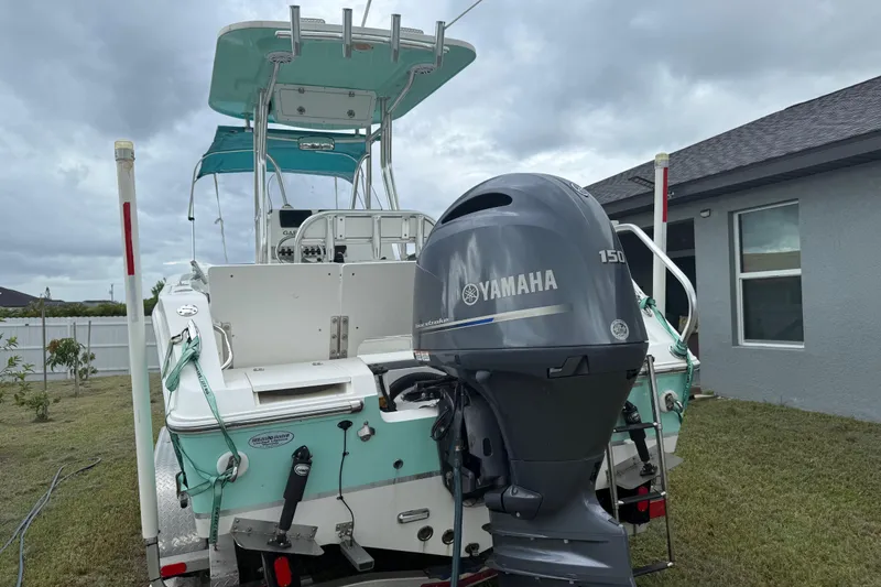 Slide: The Image of 2018 Release 208 RX boat with Yamaha 150 engine, parked in a residential yard. - 9