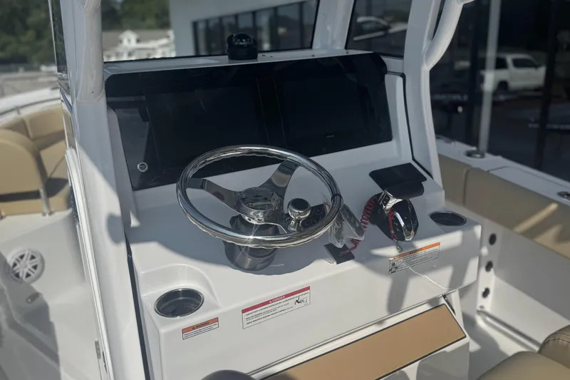Slide: The Image of 2026 Sportsman Open 232 Center Console boat dashboard with steering wheel and controls. - 12