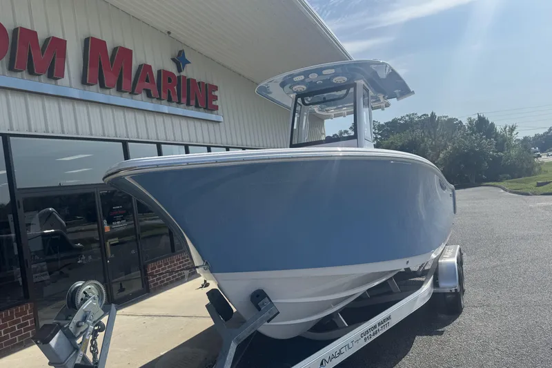 Slide: The Image of 2026 Sportsman Open 232 Center Console boat on trailer outside marine store. - 15