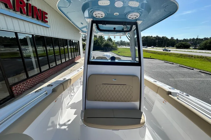 Slide: The Image of 2026 Sportsman Open 232 Center Console boat at a dealership, showcasing interior seating. - 26