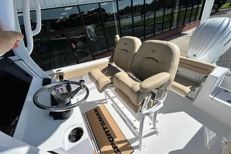 Slide: The Image of 2026 Sportsman Open 232 Center Console boat interior with beige seating and steering wheel. - 28