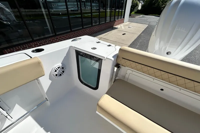 Slide: The Image of 2026 Sportsman Open 232 Center Console boat interior with beige seating and speaker. - 29