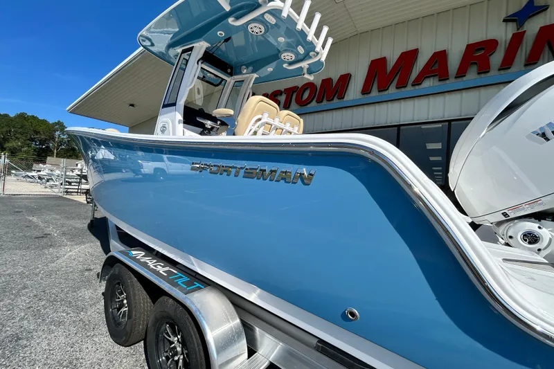 Slide: The Image of 2026 Sportsman Open 232 Center Console boat in blue, parked at a marine dealership. - 3