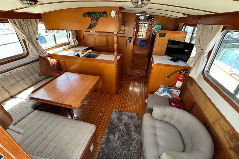 Slide: The Image of Interior of 2000 Eagle 40 Pilothouse Trawler with wood finish, seating, and TV. - 18