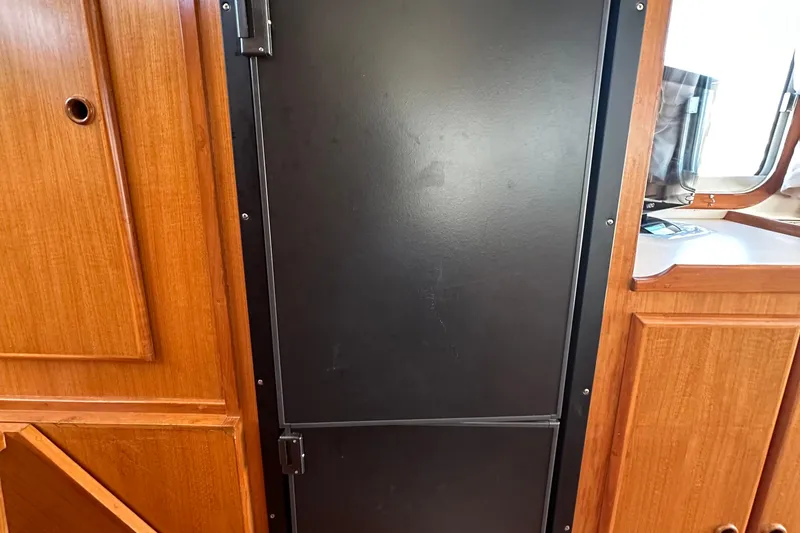 Slide: The Image of Interior of 2000 Eagle 40 Pilothouse Trawler with wooden cabinetry and black door. - 24