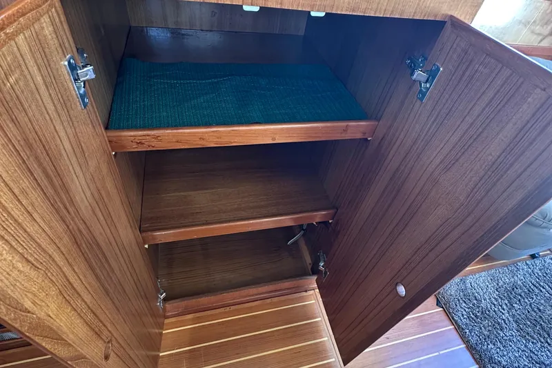 Slide: The Image of Wooden cabinet interior on 2000 Eagle 40 Pilothouse Trawler, featuring shelves and open door. - 26
