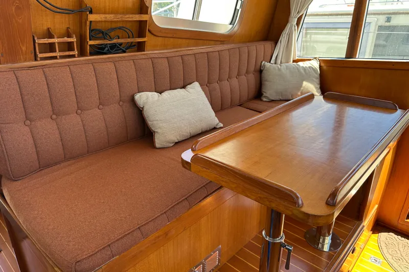 Slide: The Image of Cozy interior of 2000 Eagle 40 Pilothouse Trawler with wooden table and cushioned seating. - 29