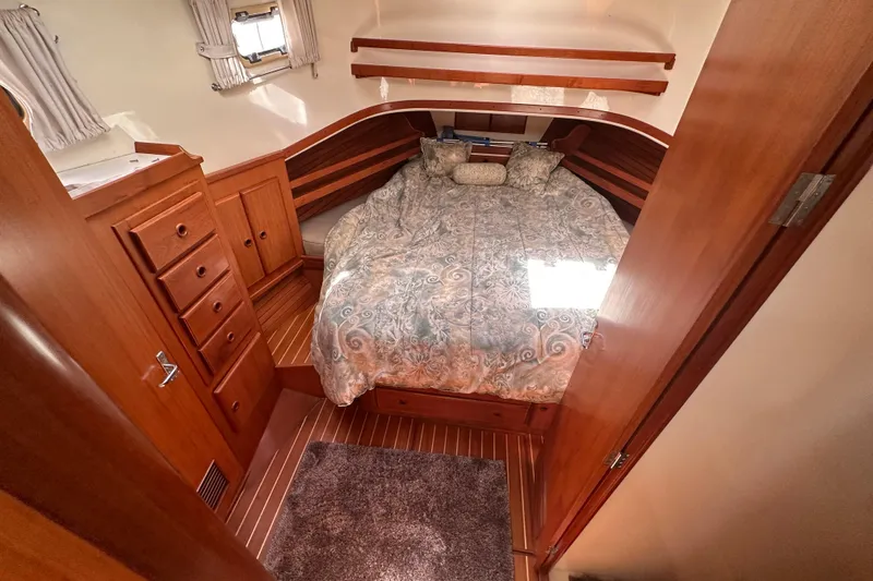 Slide: The Image of Cozy bedroom in 2000 Eagle 40 Pilothouse Trawler with wood cabinetry and patterned bedding. - 51
