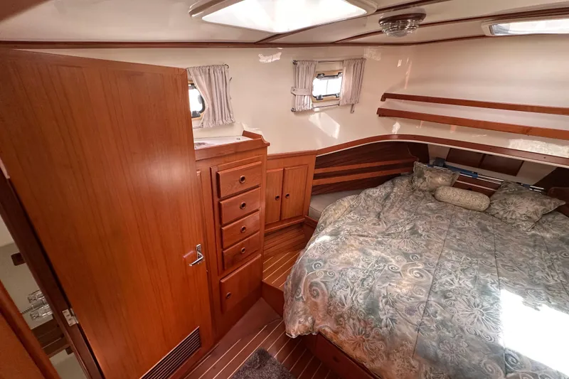 Slide: The Image of Cozy bedroom in 2000 Eagle 40 Pilothouse Trawler with wood cabinetry and patterned bedding. - 52