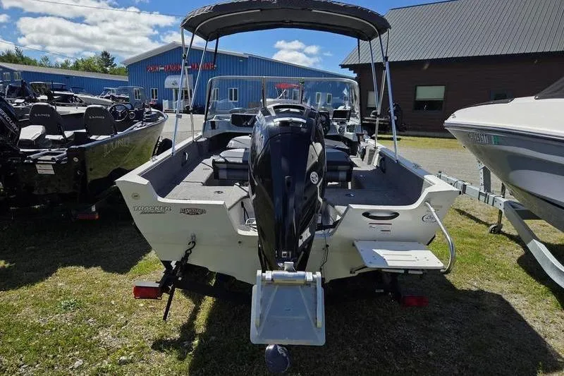 Slide: The Image of 2018 Tracker PG V16 WT boat displayed outdoors with motor and canopy. - 4