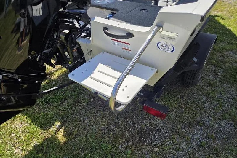 Slide: The Image of 2018 Tracker PG V16 WT boat with rear platform and motor, parked on grass. - 5