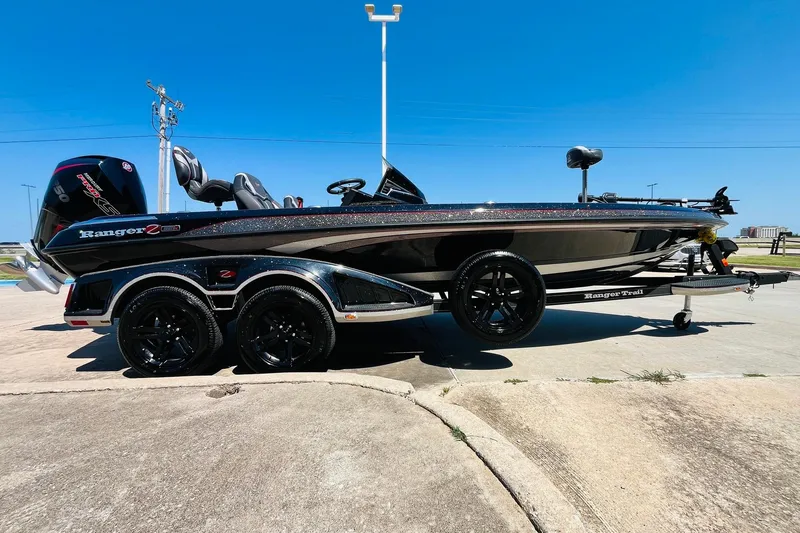 Slide: The Image of 2024 Ranger Z521R Ranger Cup Equipped boat on trailer, side view under clear blue sky. - 4