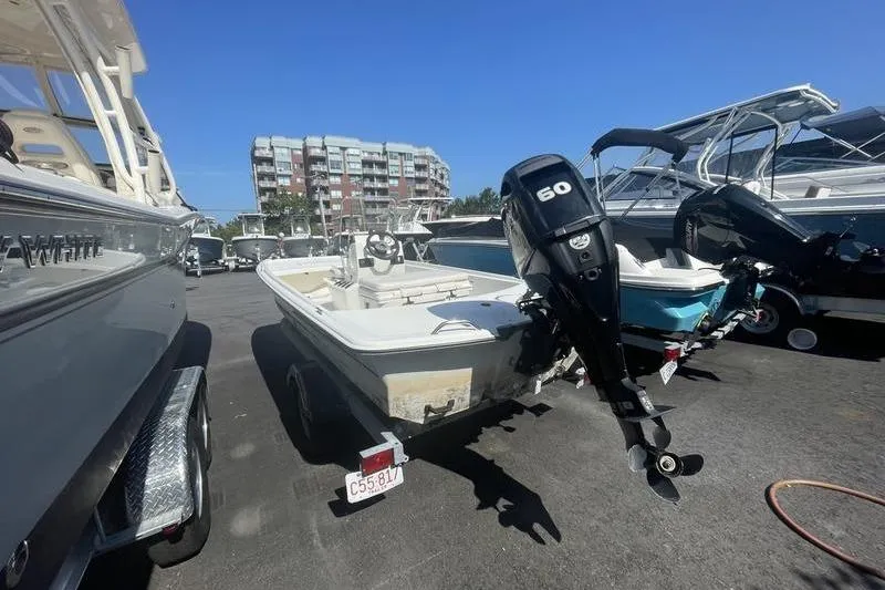 Slide: The Image of 2014 Mako Pro Skiff 17 CC with 60 HP outboard motor in a marina. - 3