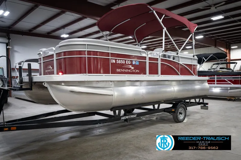 Slide: The Image of 2021 Bennington 20 SVSR pontoon boat with red canopy in indoor showroom. - 4