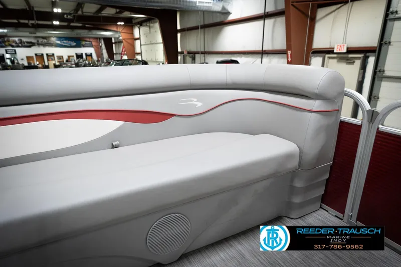 Slide: The Image of 2021 Bennington 20 SVSR pontoon boat interior with gray and red seating in a showroom. - 44