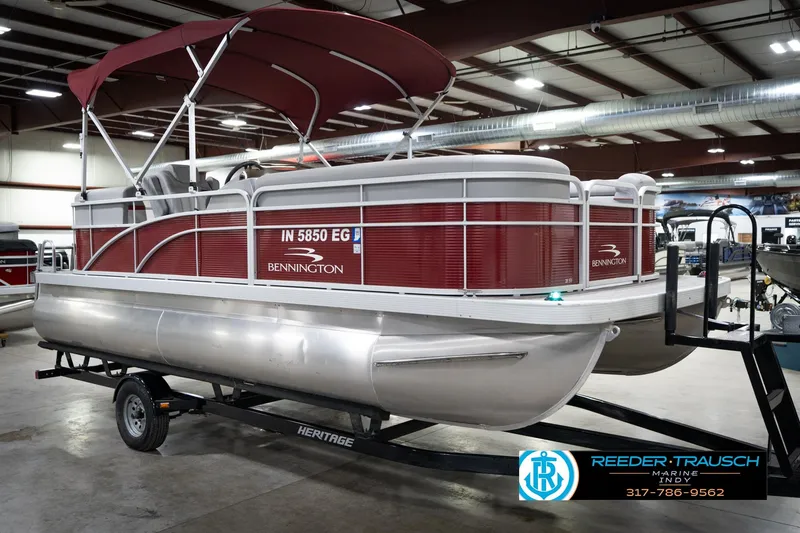 Slide: The Image of 2021 Bennington 20 SVSR pontoon boat with red canopy in indoor showroom. - 6