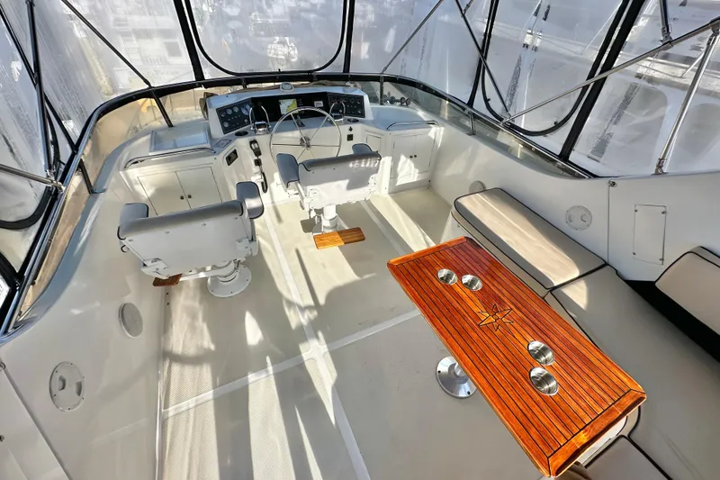 Slide: The Image of Cockpit of 2003 Ocean Alexander 42 Sport Sedan with helm, seating, and wooden table. - 30