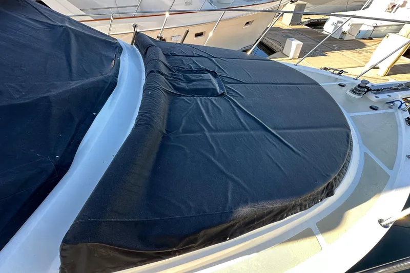 Slide: The Image of 2003 Ocean Alexander 42 Sport Sedan with black deck cover at marina. - 31