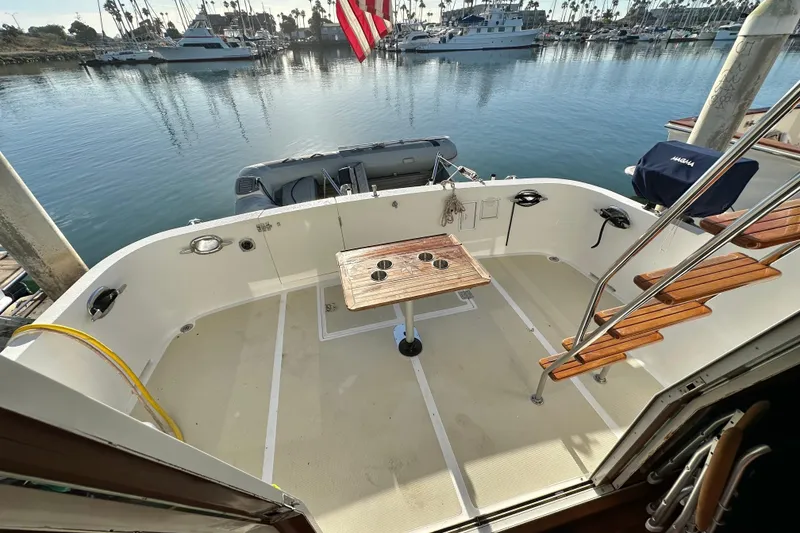 Slide: The Image of 2003 Ocean Alexander 42 Sport Sedan yacht deck with wooden table, marina view. - 5