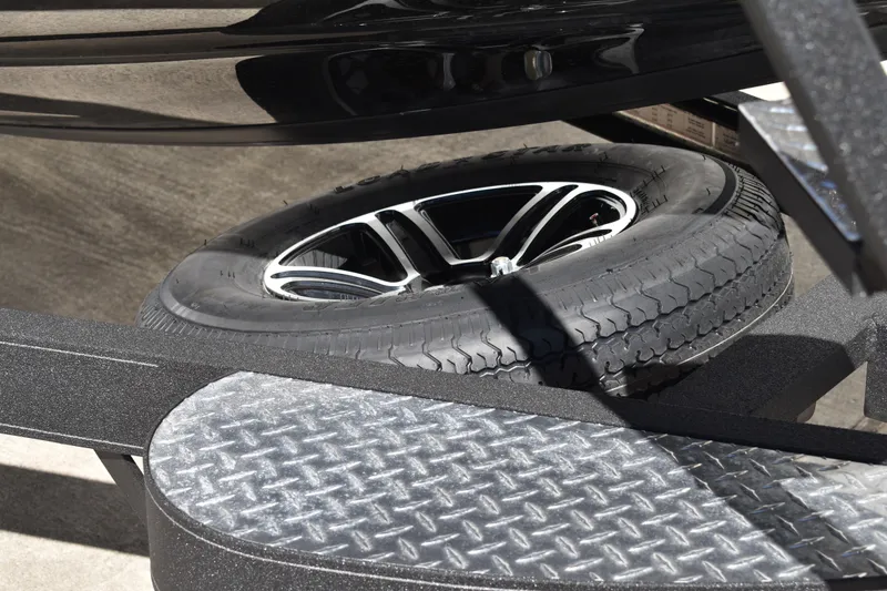 Slide: The Image of 2025 Triton 20XP Patriot boat on trailer, parked outdoors, side view. - 4