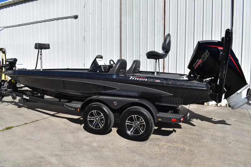 Slide: The Image of 2025 Triton 20XP Patriot boat on trailer, parked outdoors. - 7