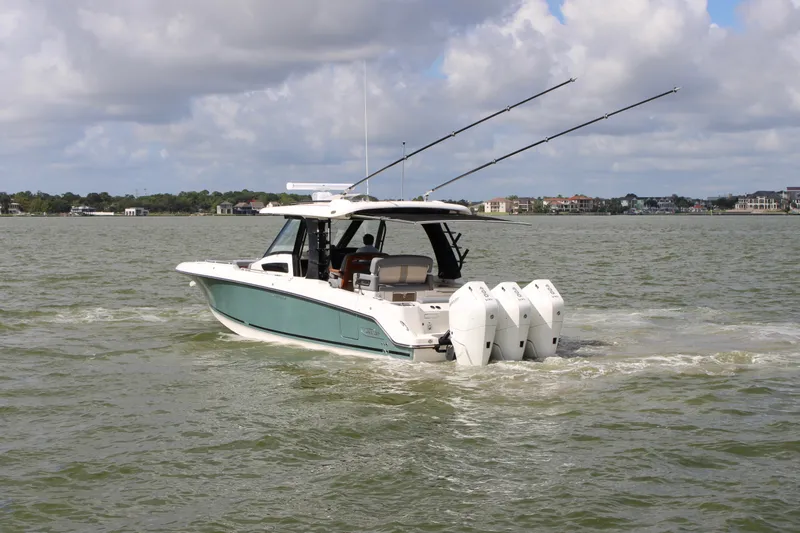 Slide: The Image of Boston Whaler 350 Realm 2026 on the water with three outboard engines and fishing rods. - 1
