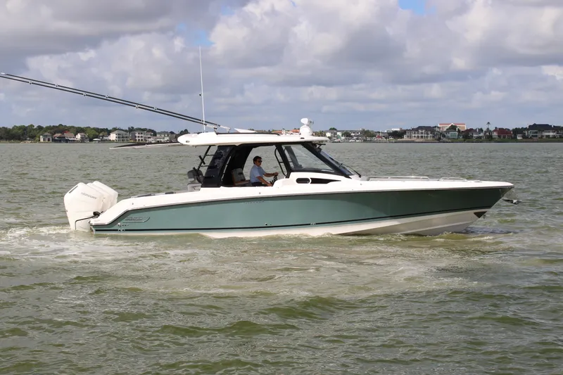 Slide: The Image of Boston Whaler 350 Realm 2026 on calm water with twin outboard engines and a spacious deck. - 4