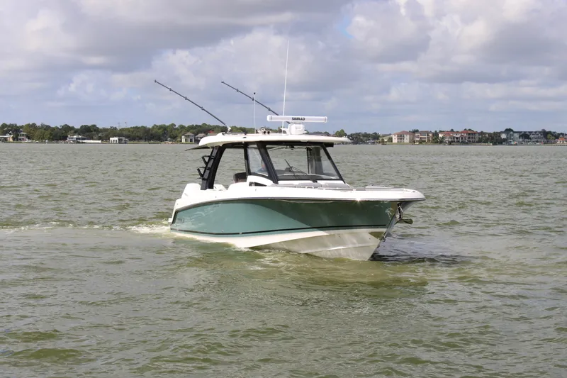 Slide: The Image of 2026 Boston Whaler 350 Realm on calm water with fishing rods and cloudy sky. - 5