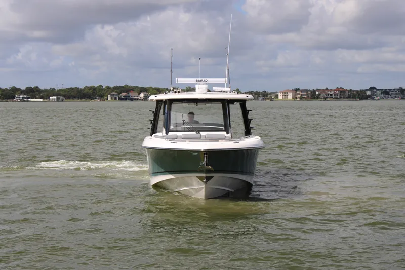 Slide: The Image of A 2026 Boston Whaler 350 Realm cruising on calm waters under a cloudy sky. - 6