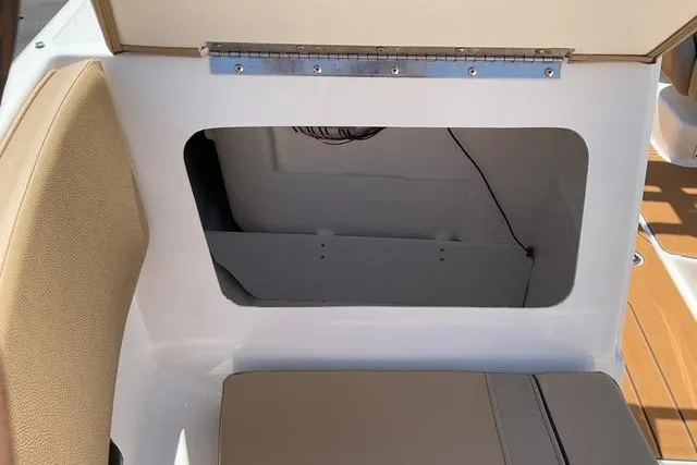 Slide: The Image of 2025 Bayliner V20i boat interior storage compartment with beige seating. - 10